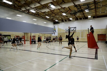 A player volleys the ball across the court during a volleyball match.